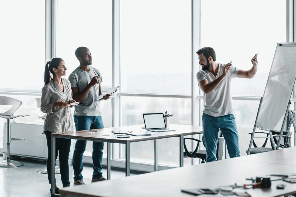Team of three co-workers in stylish studio